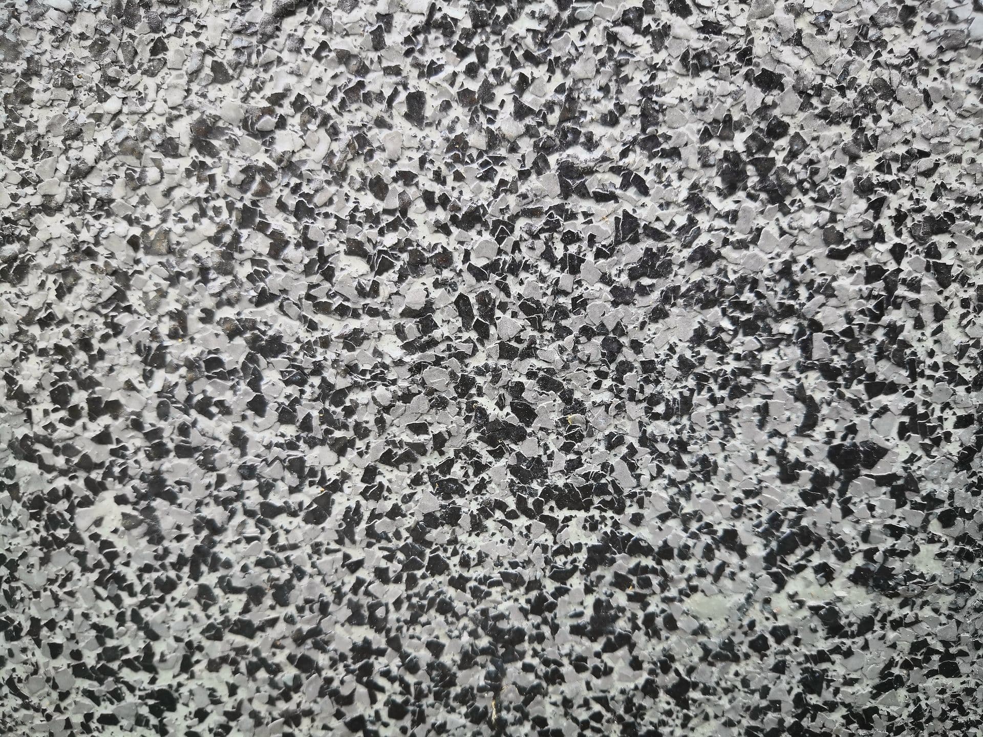 Close-up of terrazzo surface with white base and scattered black and gray stone chips throughout